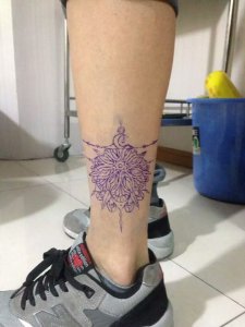 篮球运动员何先生小腿处的紫色神秘图腾纹身图案